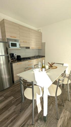 a kitchen with a white table and chairs in it at Mazzini Green Suites Jesolo in Lido di Jesolo