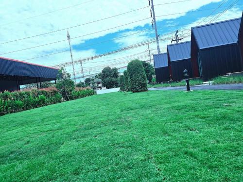 a large grassy field in front of a building at Nordic SkyBird Hill Chill in Pak Chong