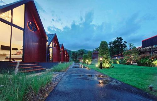 a house with a red building next to a green field at Nordic SkyBird Hill Chill in Pak Chong