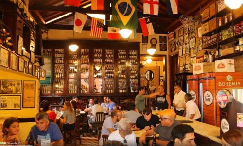un groupe de personnes assises à des tables dans un restaurant dans l'établissement Canto doce in Santa Tereza Rio de Janeiro, à Rio de Janeiro