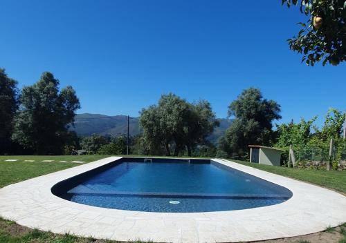 a swimming pool in the middle of a grass field at Quinta de Ramil in Vieira do Minho