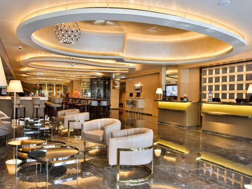 una hall di un hotel con sedie e tavoli di Palladio Hotel Buenos Aires - MGallery Collection a Buenos Aires