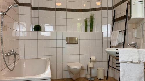 a bathroom with a tub and a toilet and a sink at Naturnahe Gästewohnung im Heidelandhaus Henzendorf in Henzendorf