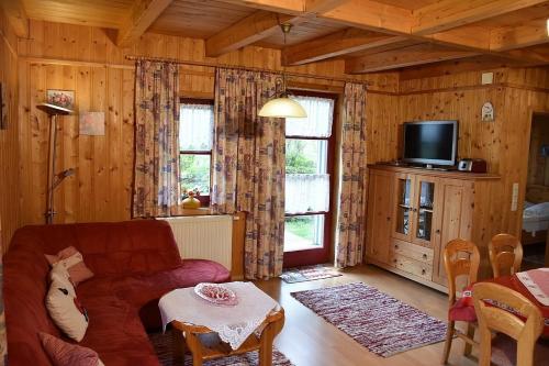 a living room with a couch and a tv at Ferienhaus Nr 7A3, Feriendorf Hagbügerl, Bayr Wald in Waldmünchen