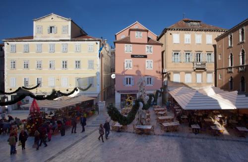 a group of people walking around a street with buildings at Luxury Room Kokola in Split