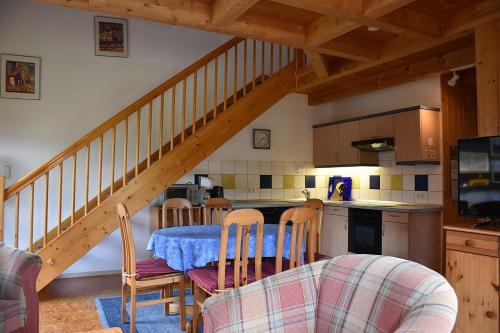a kitchen with a table and chairs and a staircase at Ferienhaus Nr 18A3, Feriendorf Hagbügerl, Bayr Wald in Waldmünchen