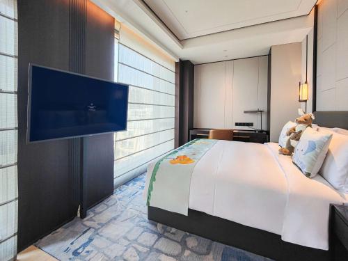 a bedroom with a large bed and a flat screen tv at Kempinski Residences Guangzhou - Free shuttle between hotel and Exhibition Center during Canton Fair & Exhibitor registration Counter in Guangzhou