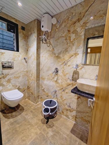 a bathroom with a toilet and a sink at Hotel Status Residency in Navi Mumbai