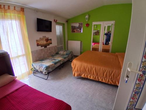 a bedroom with green walls and two beds and a couch at Villa Carolina in Fara San Martino