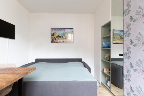 una camera da letto con un letto e un tavolo di legno di Tourbillon a Sion