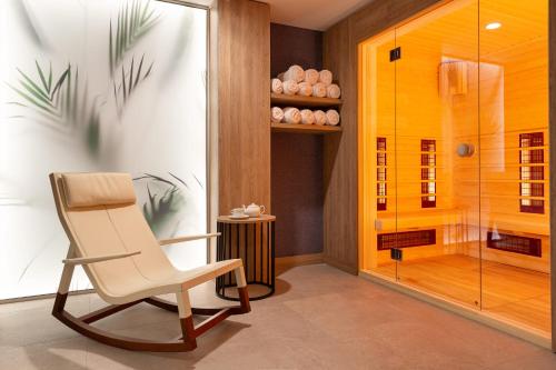 a rocking chair in a room with a shower at Mercure Sofia City in Sofia