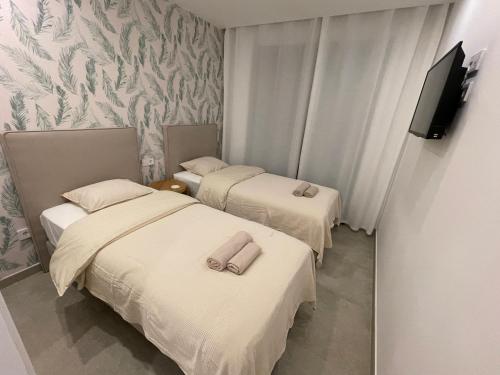 two beds in a hotel room with towels on them at Gran Alcant Iconic Apartment Riki in Gran Alacant