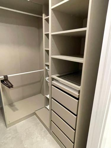 a walk in closet with white shelves at Gran Alcant Iconic Apartment Riki in Gran Alacant