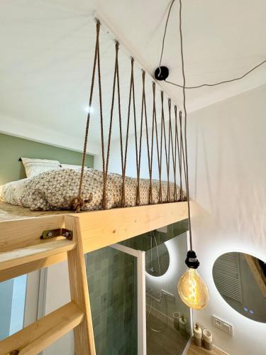 - une chambre avec une balancelle et un miroir dans l'établissement Jardin enchanté, city center, à Mulhouse