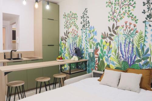 - une chambre avec un lit et une fresque murale colorée dans l'établissement Jardin enchanté, city center, à Mulhouse