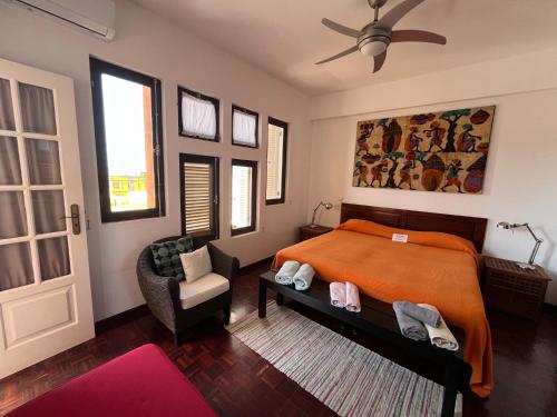a bedroom with an orange bed and a chair at Vila Mira Mar in Mindelo