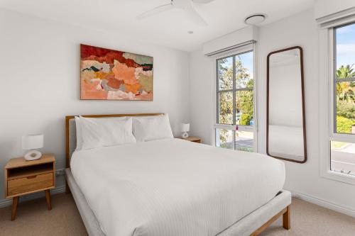 a bedroom with a white bed and two windows at Hampton Beach Pearl in Hampaton