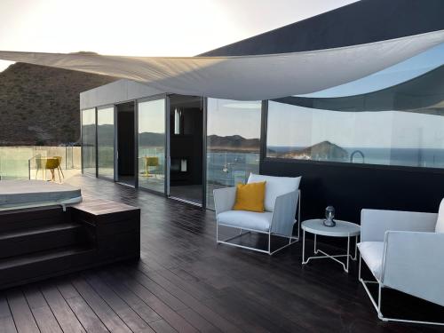 a living room with white furniture and glass windows at Los Genoveses Penthouse in San José