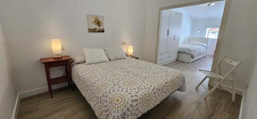 a bedroom with a bed and a table and a chair at Apartamento Magdalena II in Ferrol