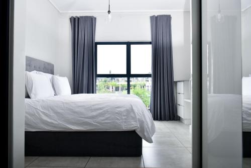 a bedroom with a bed and a large window at Feelathome in Midrand