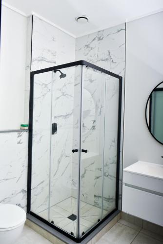 a glass shower in a bathroom with a toilet at Feelathome in Midrand