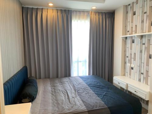 a bedroom with a bed and a large window at The Blu X See Sea F6 R153 in Ban Bang Saen (1)