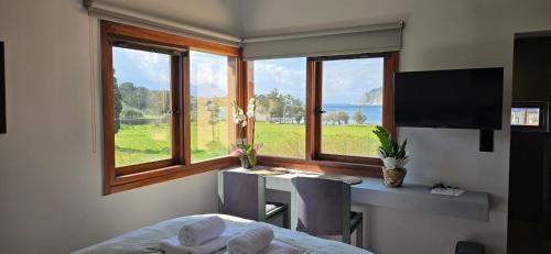a bedroom with a desk and a window with a view at Perivleptos ΙI in Perdhika