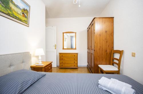 a bedroom with a bed and a chair and a dresser at Casa Vera in Torrevieja