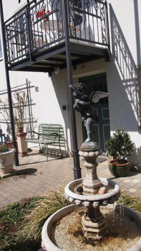 a fountain in front of a building with a balcony at Im Juchhe in Peiting