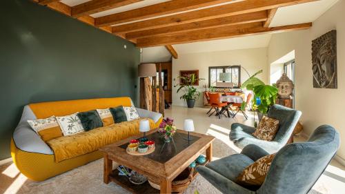 un salon avec un canapé, deux chaises et une table dans l'établissement Chez Cécile et Marco, à Moissac