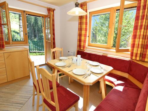a dining room with a table and chairs and windows at Large Apartment in Maria Alm with Terrace in Maria Alm am Steinernen Meer
