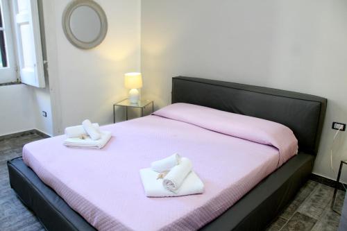 a bedroom with a pink bed with towels on it at B&B al CORSO in Salerno