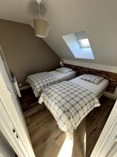 deux lits dans une petite pièce avec une fenêtre dans l'établissement Appartement avec cour 3, à Briare