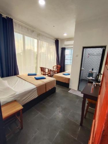 a hotel room with two beds and a desk at Perhentian Najmi Hotel in Perhentian Island