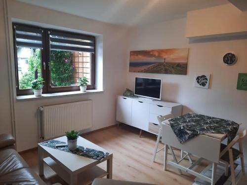 a living room with a table and a television at Nielsen Appartment 2 in Hüsby