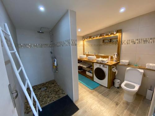 łazienka z toaletą, umywalką i pralką w obiekcie Villa Bleue des Sables hypercentre marina plage w mieście Saint-François