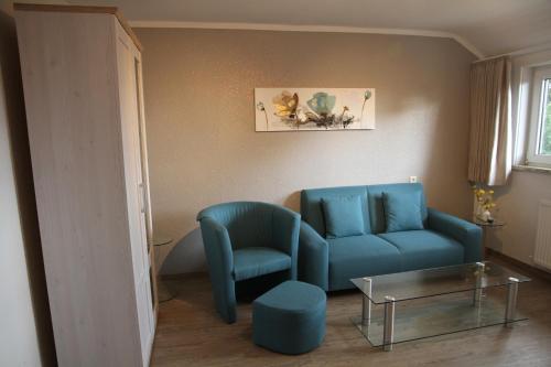 a living room with a blue couch and a table at Wohnung Julius 4 in Sankt Andreasberg