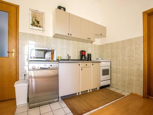 kuchnia z urządzeniami ze stali nierdzewnej i białymi szafkami w obiekcie Apartment in Seline near the sea with seaview w mieście Starigrad-Paklenica
