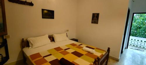a bedroom with a checkered bed and a window at Agasthya in Varkala