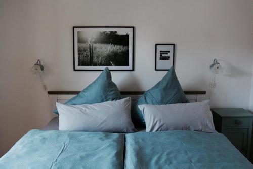 a bedroom with a bed with blue sheets and pillows at Landhaus Weserbergland - Karl in Vahlbruch