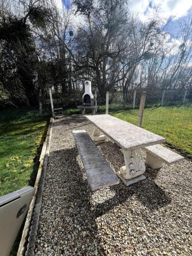 une table de pique-nique avec un banc dans un parc dans l'établissement Appartement avec cour 1, à Briare