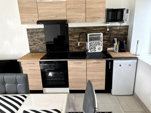 une cuisine avec des armoires en bois et un four à plaques de cuisson dans l'établissement Appartement avec cour 1, à Briare