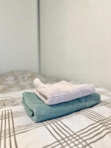- une pile de serviettes assises au-dessus d'un lit dans l'établissement Chic Apt in Central Paris Ecouffes in Marais, à Paris