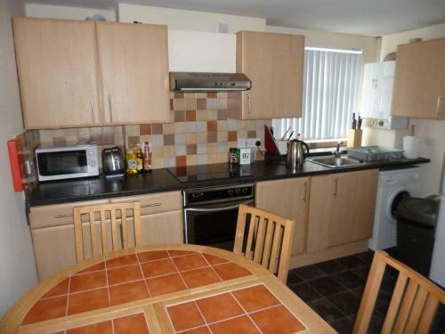 a small kitchen with a table and a microwave at Malone Townhouse in Belfast
