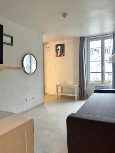 une chambre avec un lit, une table et une fenêtre dans l'établissement Chic Apt in Central Paris Ecouffes in Marais, à Paris