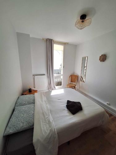 une chambre avec un grand lit blanc avec une fenêtre dans l'établissement Le Cocon des Bluetwins, à Caen