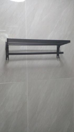 a black bench in a room with a wall at บ้านแม่โฮมสเตย์ in Ban Pa Kwao