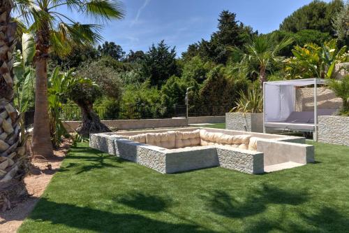 un jardin avec un canapé dans la pelouse dans l'établissement Brand new 6 bedroom villa with pool, à Vallauris