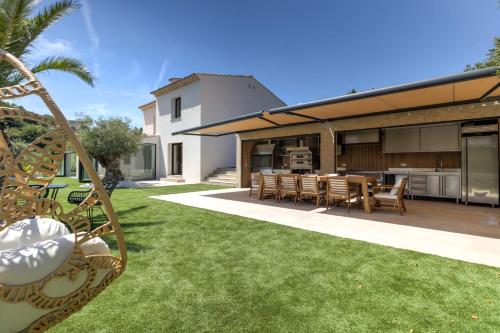 un patio extérieur avec une table et des chaises dans l'établissement Brand new 6 bedroom villa with pool, à Vallauris