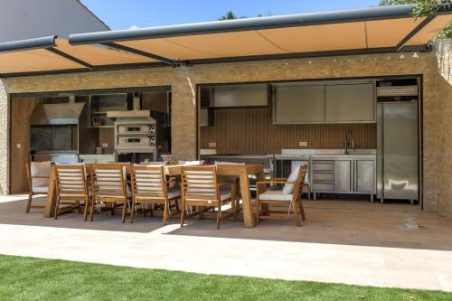 un patio avec une table et des chaises et une cuisine dans l'établissement Brand new 6 bedroom villa with pool, à Vallauris